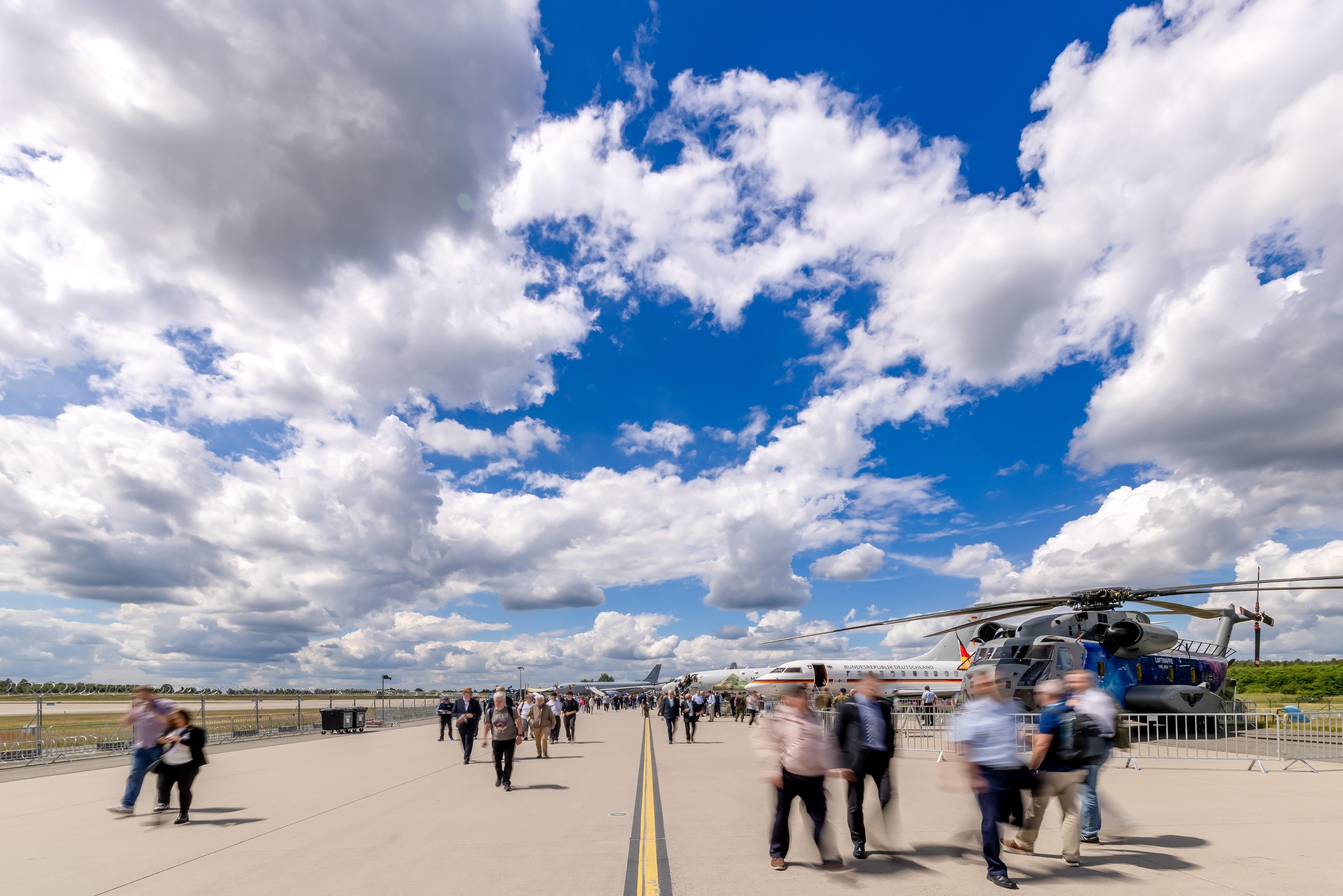 Rollbahn-Panorama der ILA 2026 mit Besuchern unter Wolkenhimmel