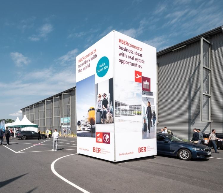 Freistehender Werbeturm mit großflächiger Markenwerbung an einer Geländeachse der ILA.